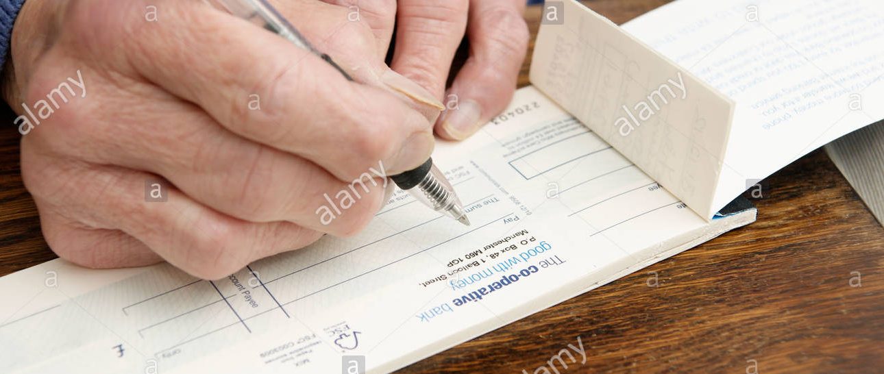elderly-woman-writing-a-cheque-co-operative-bank-cheque-book-co-operative-d9dn2c: SVH